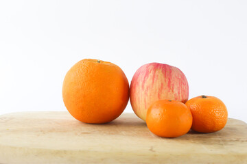 Selective focus of Apple and Big oranges on a wooden table isolated on white background