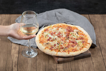 Big portion margarita pizza with a glass of white wine around