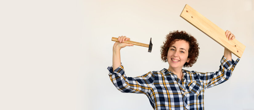 Woman holds a wood and hammer for DIY