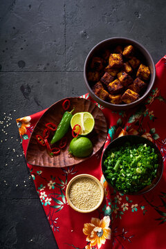 Ingredients for cooking vegetarian ramen with tofu laid on the dark background