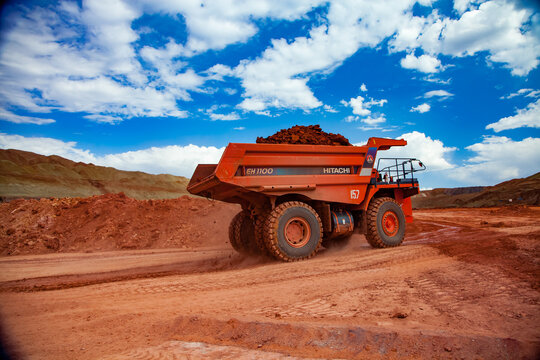 Arkalyk, Kazakhstan - May 15, 2012: Aluminium Ore Mining And Transporting.. Open-cut (Quarry) Mining. Orange Hitachi Quarry Dump-truck With Bauxite Clay.