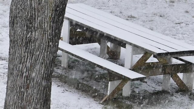 Wooden table outside covered with snow in winter