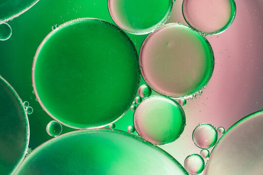 Closeup of abstract background with round shaped cells of vaccine of different sizes illuminated by colorful light