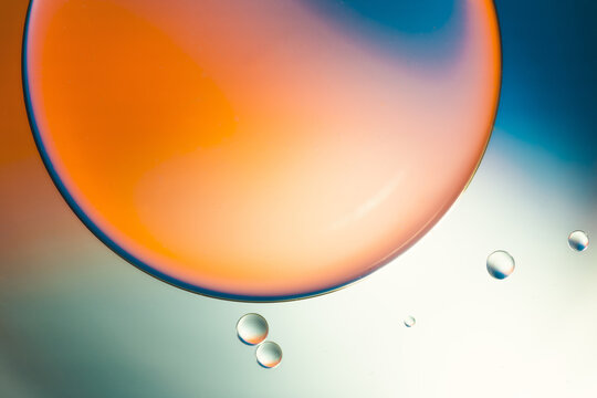 Closeup of abstract background with round shaped cells of vaccine of different sizes illuminated by colorful light