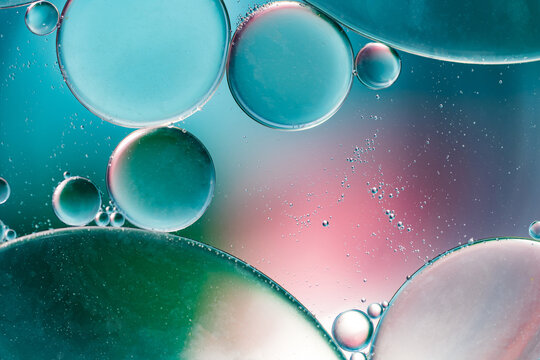 Closeup of abstract background with round shaped cells of vaccine of different sizes illuminated by colorful light