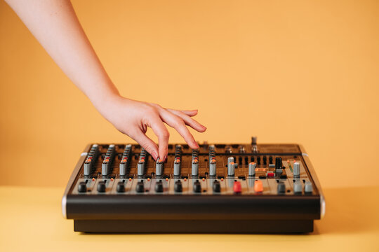 Crop hand of woman using equalizer in music studio on blurred background