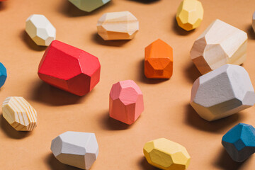 From above of full frame background of assorted wooden blocks in shape of gems scattered on beige table