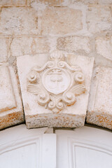 Close-up of a convex architectural relief depicting symbols.