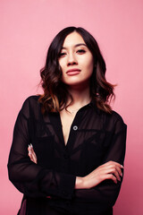 young pretty girl with curly hair posing cheerful on pink background, lifestyle people concept