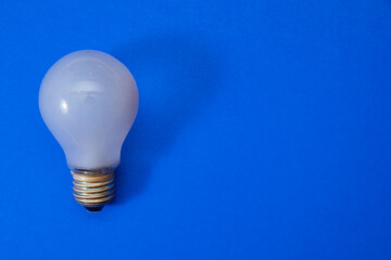 White lightbulb on a blue background. Old light bulb. Concept of energy. Copy paste space 