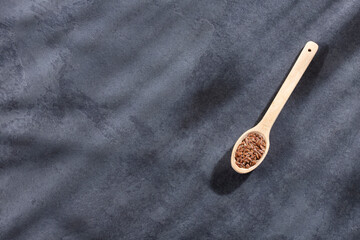 Linum usitatissimum - Organic flax seeds in wooden spoon