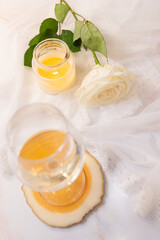 Glass of white wine, rose and candle on a white background. 8th march and valentine's day concept