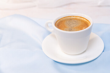 white cup of coffee on blue cloth