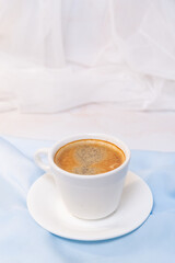 white cup of coffee on blue cloth