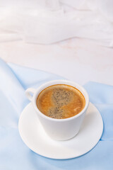 white cup of coffee on blue cloth