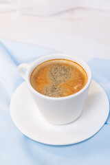 white cup of coffee on blue cloth