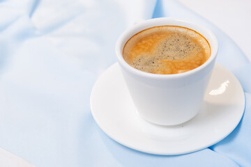 white cup of coffee on blue cloth