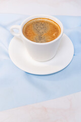 white cup of coffee on blue cloth