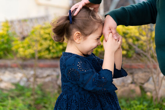 Little baby girl kiss her grandmother's hand during Eid mubarak (Turkish Ramazan or Seker Bayram). Adorable child kiss elderly woman hand to show respect. Cute toddler follow muslim Ramadan traditions