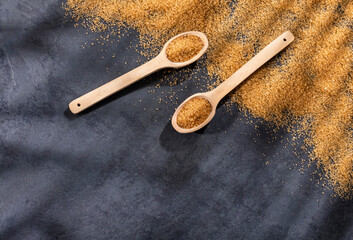 Saccharum officinarum - Organic brown sugar in wooden spoons
