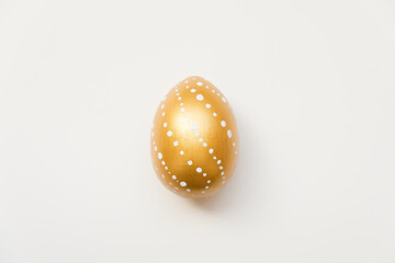 Easter golden decorated egg isolated on white background. Minimal easter concept. Happy Easter card with copy space for text. Top view, flatlay. Concept for banner, flyer, invitation, greeting card