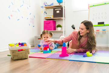 Young woman having a child therapy session with a little girl