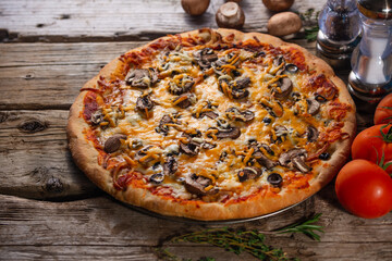 Pizza with mushrooms and cheese on a wooden background