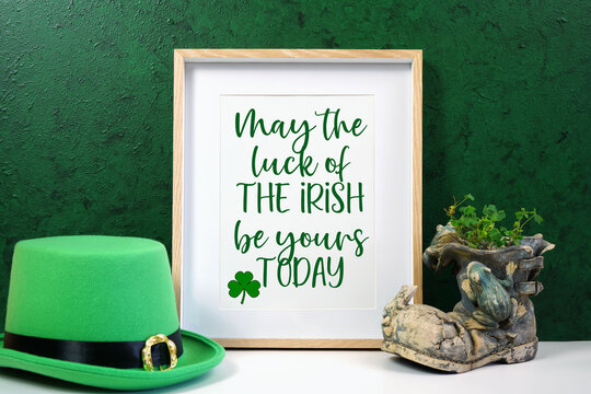 Happy St Patrick's Day vertical wood border picture frame, styled with leprechaun hat, shamrocks, and chocolate gold coins, on a textured green background. May the luck of the Irish text.