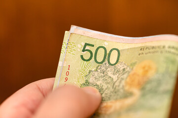 Peso Argentino. Dinheiro, Argentina, Finanças e economia. Uma pessoa segurando notas do dinheiro...