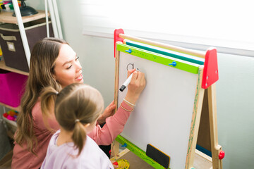 Homeschool mom teaching a little girl how to write