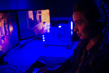 Gamer girl playing in front of a big TV, screen in games, e-sports, gamer, streamer, streaming games