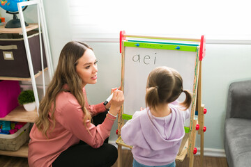 Female teacher tutoring a cute girl at her home