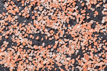 Himalayan pink salt crystals on black background, space for text