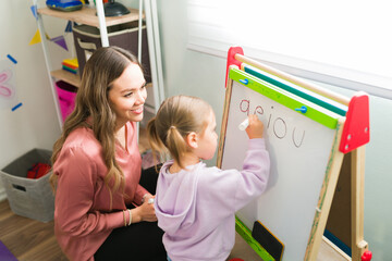 Female tutor teaching the alphabet a preschool girl