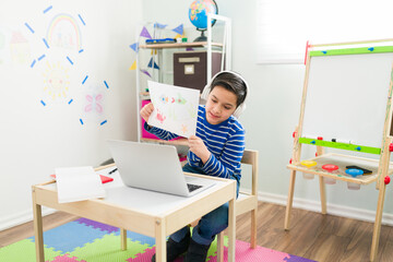 Little boy feeling proud of his art work for a virtual class
