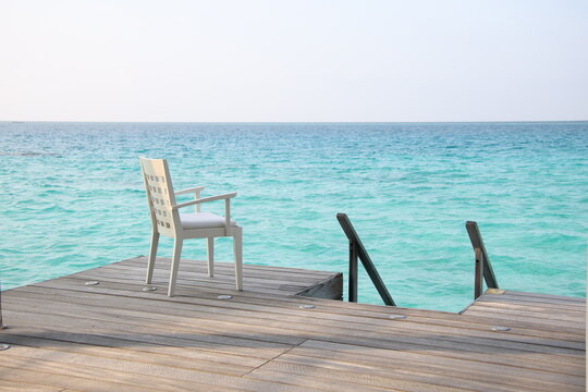 Lonely chair on wooden terrace at the sea