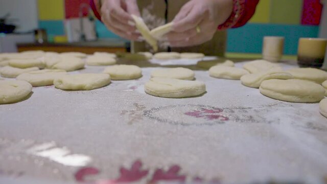 Woman hands making donuts in a home kitchen - reverse, dolly view