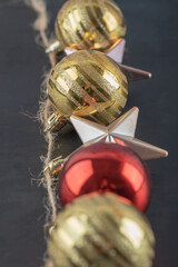 Colorful ornaments hanged from the rustic thread on the dark stone background