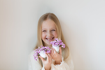 Naklejka premium kid holding hands Cute Easter eggs with drawn faces and floral purple wreath