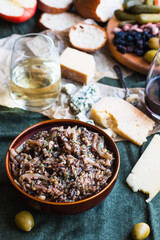 Wild rice salad surrounded by cheese board condiments and wine