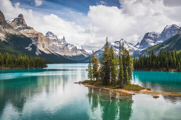 The famous Spirit Island of Maligne Lake in Jasper National Park of Alberta, Canada. Vivid blue-green waters of the glacially fed lake shine in the sunshine around the famous gathering of pines.