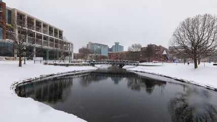 Kalamazoo, Michigan, USA - February 5 2021: Downtown Kalamazoo in snow. view from Arcadia Creek playground.