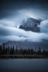 Mount Rundle in Banff shrouded in moody clouds and fog as viewed from Vermilion Lakes in late September. 