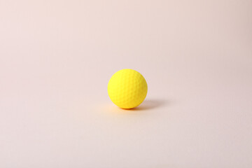 a golf ball of various colors with a pink background