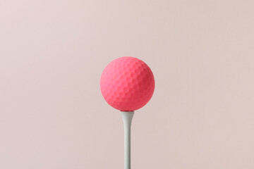a golf ball of various colors with a pink background