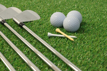 Golf balls and clubs on the grass