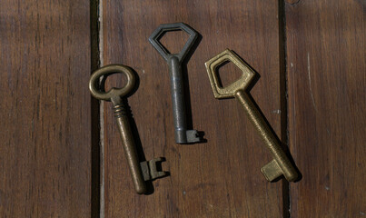 Set of old door keys on wood.