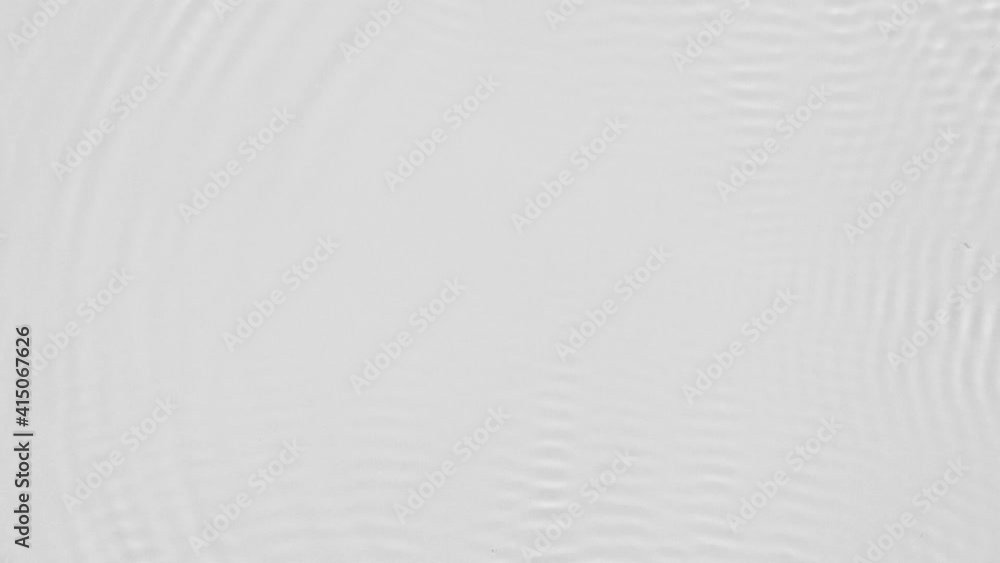 Poster Close up top view of water droplets falling into the water and separate splashes of water on gray background in 4k slow motion.