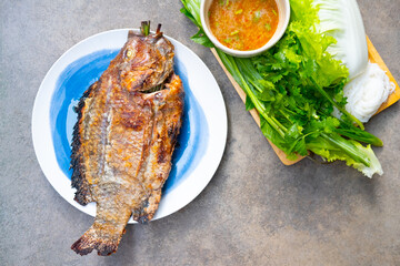 Tilapia grilled with salt in Thai style food eating with seafood sauce and fresh vegetable