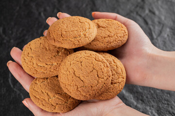 A chef holding oatmeal cookies in the hand